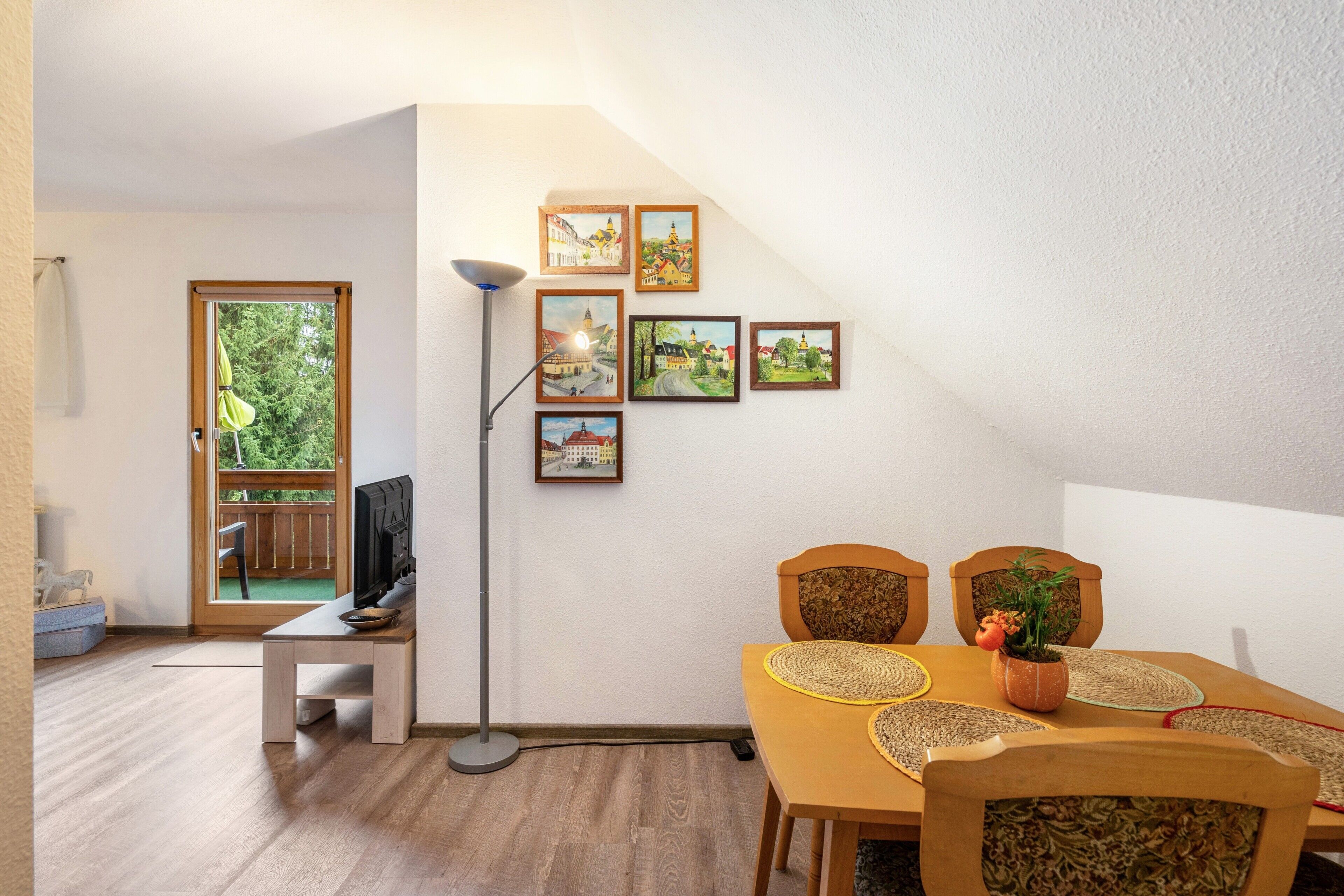 Ein Essbereich mit Holztisch, Stühlen und einer Stehlampe.