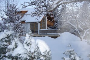Un edificio cubierto de nieve con amplios ventanales y un balcón de madera.