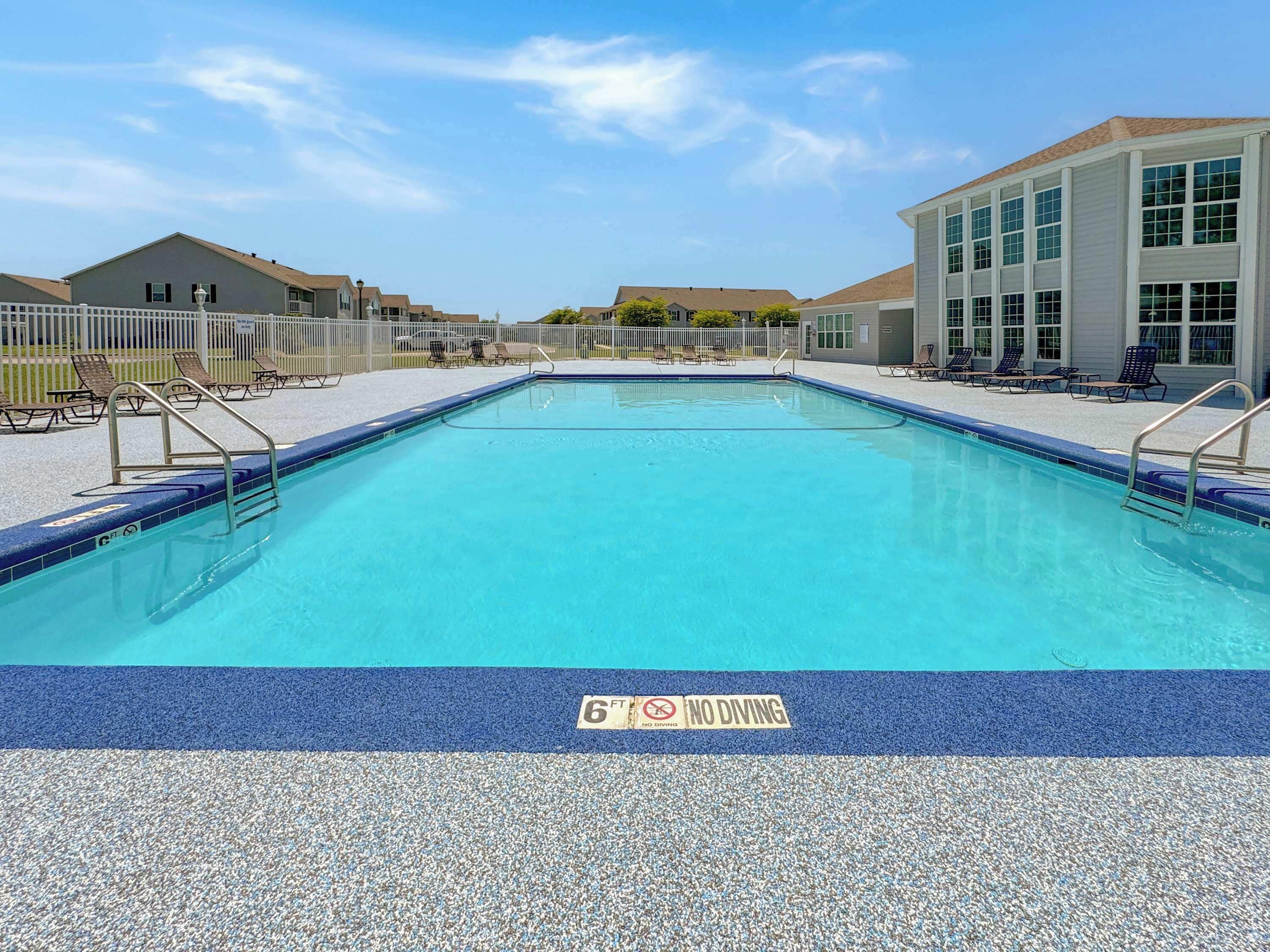 A rectangular swimming pool with a blue border and a 'No Diving' sign.