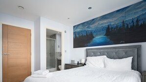 A modern bedroom with a large bed, a wooden door, a glass shower enclosure, and a painting of a forest scene. - Pass the Keys |Modern 2bed Apartment Edinburgh (Edinburgh)