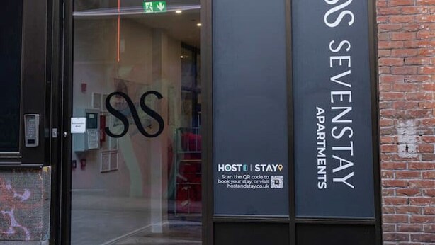 Un edificio moderno con un letrero que dice "SS SEVENSTAY APARTMENTS".
