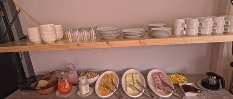 Una mesa con diversos alimentos y utensilios para un bufé.
