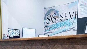 A reception desk with a herringbone wood pattern and a logo. - Sevenstay Fleet Apt34 (Merseyside)