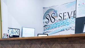 A reception desk with a herringbone wood pattern and a logo. - Sevenstay Fleet Apt51 (Merseyside)