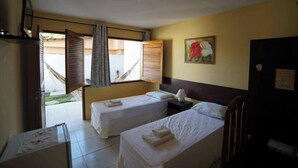 Una camera d'albergo con due letti singoli, una scrivania, una sedia, una finestra con tende e un quadro appeso al muro.