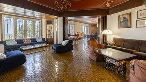 Eine geräumige Lobby mit gefliestem Boden, Sitzbereichen und Blick durch große Fenster.