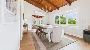 A dining room with a wooden ceiling, large windows, and a chandelier. - Eureka Hotel (New Shoreham)