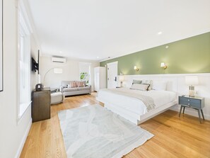 A modern bedroom with a large bed, a sofa, and a desk. - Eureka Hotel (New Shoreham)