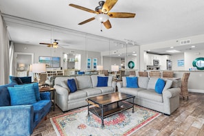 A spacious living room with a sofa, armchairs, a coffee table, and a ceiling fan. - Sterling Sands 606 (Destin)