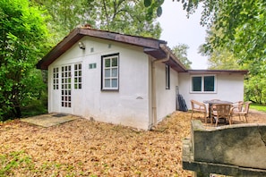 A small, single-story building with a white exterior, a front door, and a window. - Gîte Le Martin Pêcheur - Domaine l'Étang des Mirandes with Shared Pool (Varaignes)