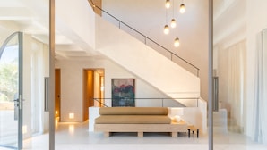 A modern interior with a staircase, a sofa, and a painting. - Country House 'Agata' with Private Pool, Wi-Fi and Air Conditioning (Illes Balears)