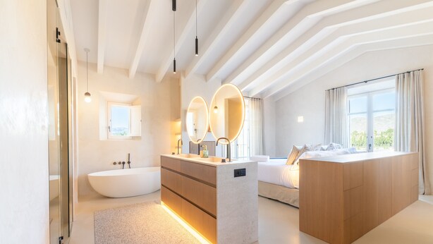 A modern bathroom with a freestanding bathtub, a vanity with a mirror, and a large window providing natural light. - Country House 'Agata' with Private Pool, Wi-Fi and Air Conditioning (Illes Balears)