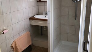 A bathroom with a toilet, sink, shower, and a window. - Gîte Le Lavoir - Domaine l'Étang des Mirandes with Shared Pool (Varaignes)