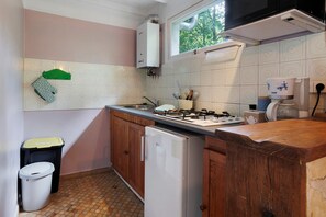 A compact kitchen with a gas stove, a refrigerator, and a microwave. - Gîte Le Lavoir - Domaine l'Étang des Mirandes with Shared Pool (Varaignes)