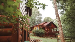 Un chalet rustique doté d’une terrasse en bois et d’une cour clôturée.