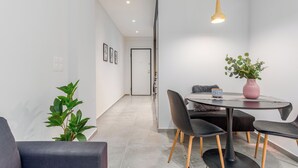 A modern dining area with a round table, black chairs, and a potted plant. - Penelope's Charming 2-BR Apt in Athens (Athens)