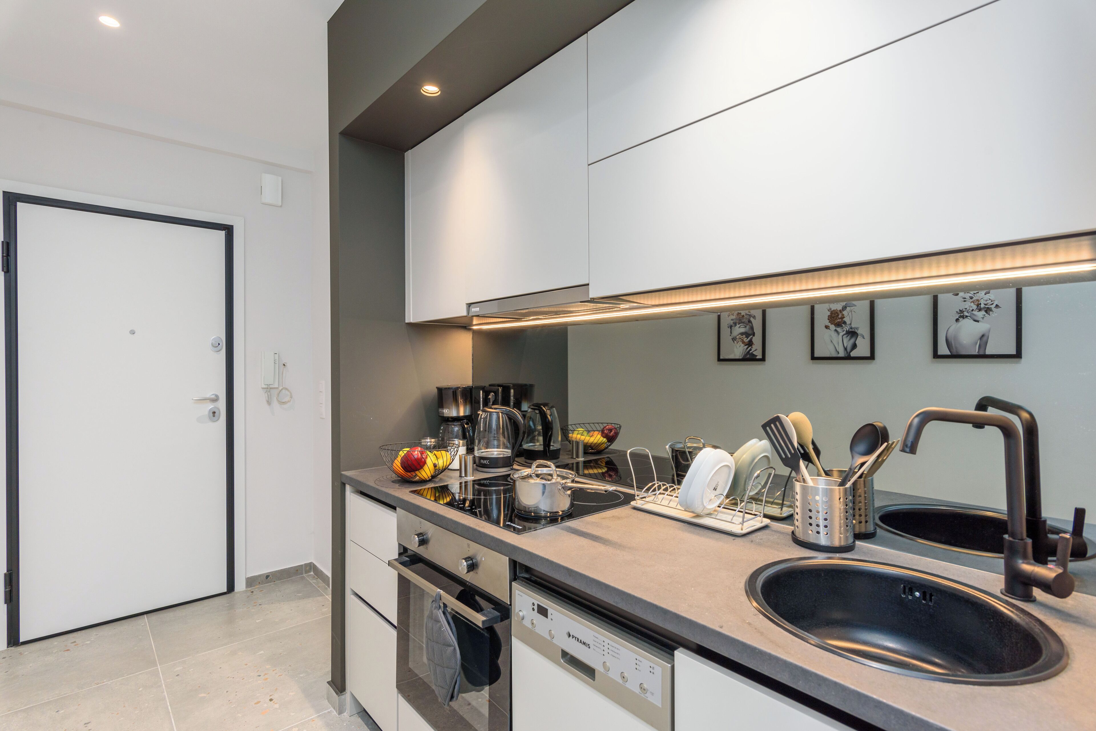 A modern kitchen with a double sink, stainless steel appliances, and a built-in oven.