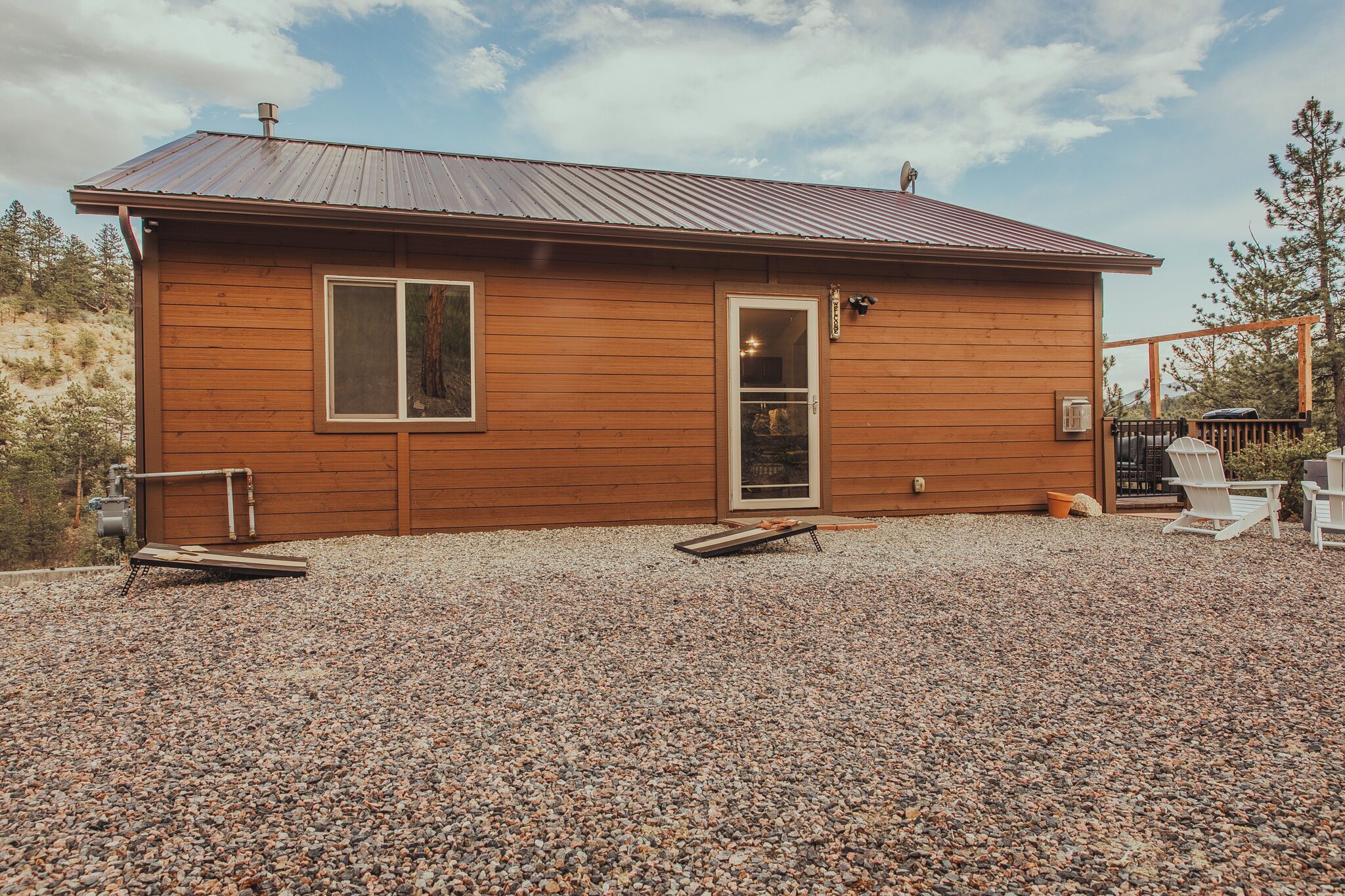 Une cabane en bois avec une allée en gravier, une porte et une fenêtre.