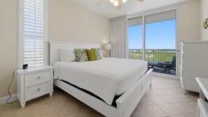 A bedroom with a bed, nightstand, and a ceiling fan. - Palacio 1506 (Pensacola)