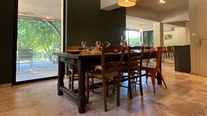 A dining area with a table set for four, chairs, and hanging pendant lights.