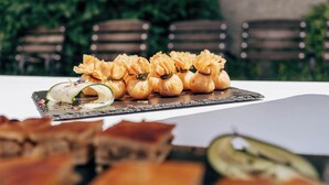 Una mesa con pasteles y un pastel, y sillas al fondo.