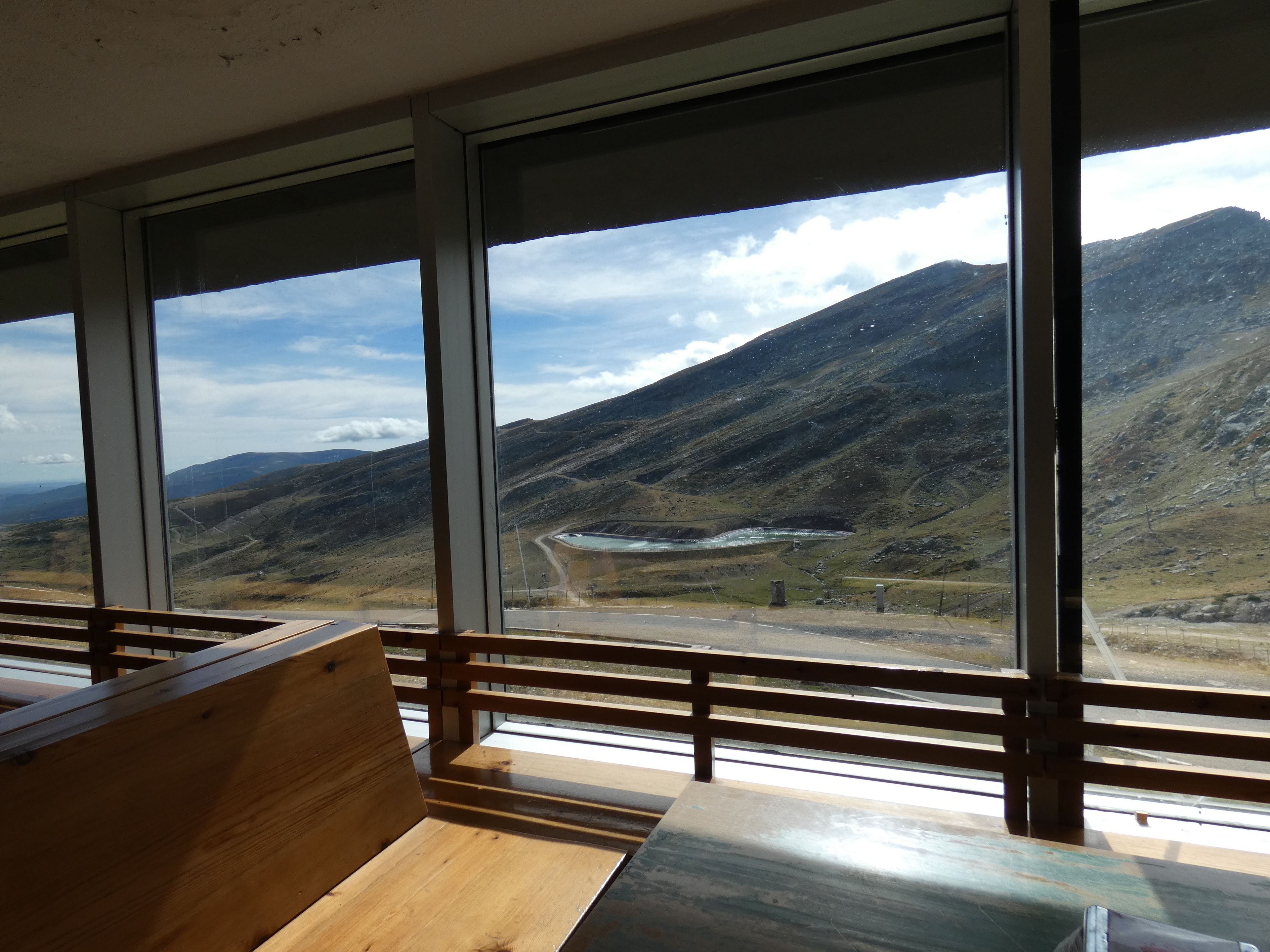Una habitación con ventanas amplias que ofrecen vistas a un paisaje montañoso.