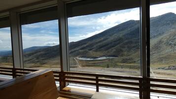 Una habitación con ventanas amplias que ofrecen vistas a un paisaje montañoso.
