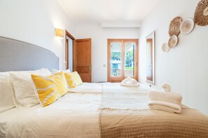 Une chambre d’hôtel avec un lit, une porte, une fenêtre et un mur décoré.