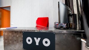 A reception desk with a sign reading "OYO" and a red chair. - HOTEL STAY INN (Lucknow)