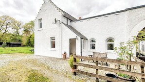 A white building with a sloped roof, a wooden fence, and a gravel driveway. - Spacious Argyll Farmhouse in an Idyllic Setting (Dunoon)