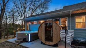 Een modern huis met een jacuzzi, een sauna en een overdekt terras.
