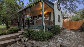 A house with a porch, stone steps, and a wooden fence.