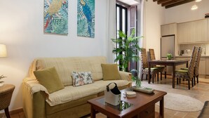 Una sala de estar con un sofá, una mesa de centro y un comedor con sillas y una mesa.