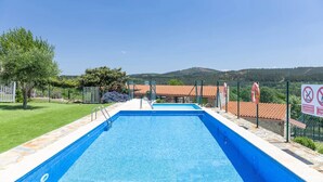 Una piscina rectangular con superficie de agua azul cristalina, rodeada por una solana de piedra y concreto.