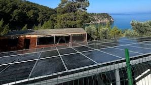 Un ensemble de panneaux solaires doté d’une structure en bois, offrant une vue sur un paysage côtier.