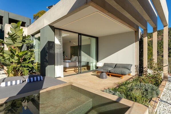 Ein moderner Außenbereich mit Pool, Sitzgelegenheiten und Blick ins Innere.