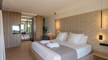 Una habitación de hotel moderna con una cama grande, un escritorio de madera y vistas al exterior.