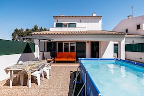 A poolside area with a table and chairs, a covered seating area, and a swimming pool. - Villa 'D' Ana' with Private Pool, Private Garden and Wi-Fi (Sesimbra)