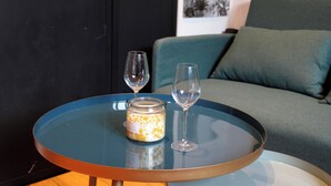 A glass table with a jar and two wine glasses.