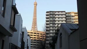 A view of the Eiffel Tower from a narrow street between buildings.