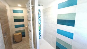 Une salle de bain moderne équipée d’une douche, de toilettes et d’un lavabo.