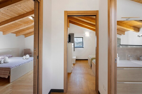 A bedroom with a bed, bedside table, and a view of the outside.