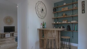 Una cocina moderna con barra, taburetes de madera y un gran elemento decorativo en la pared.