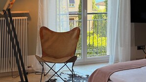 Une pièce comprenant un lit, une chaise, un radiateur, une lampe et une fenêtre donnant sur une vue sur la montagne.
