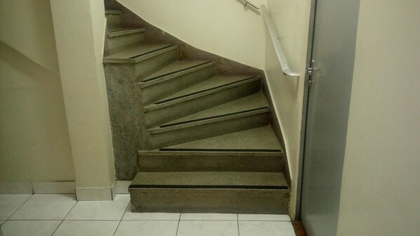 Un escalier en colimaçon doté d’une rampe, menant à l’étage supérieur.