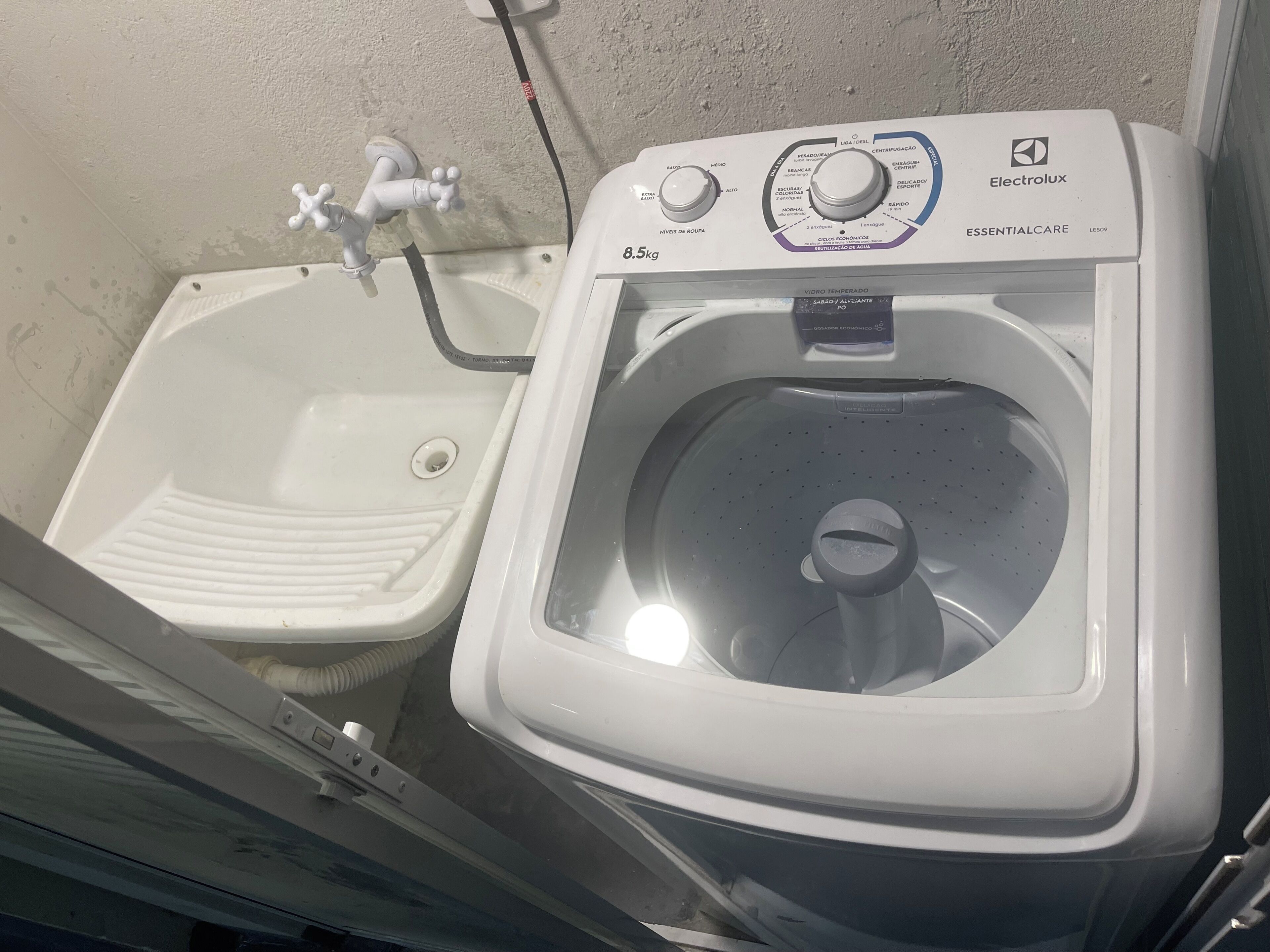 A compact bathroom with a white sink and a white washing machine.