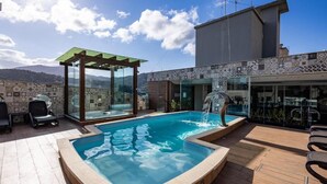 A rooftop pool with a glass enclosure, lounge chairs, and a view of the mountains. - Nilmare Apart Hotel (Itapema)