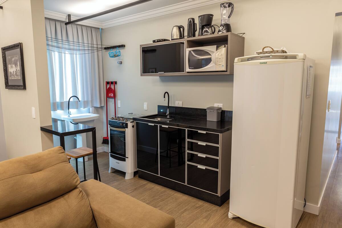 A compact kitchen with a microwave, stove, and refrigerator.