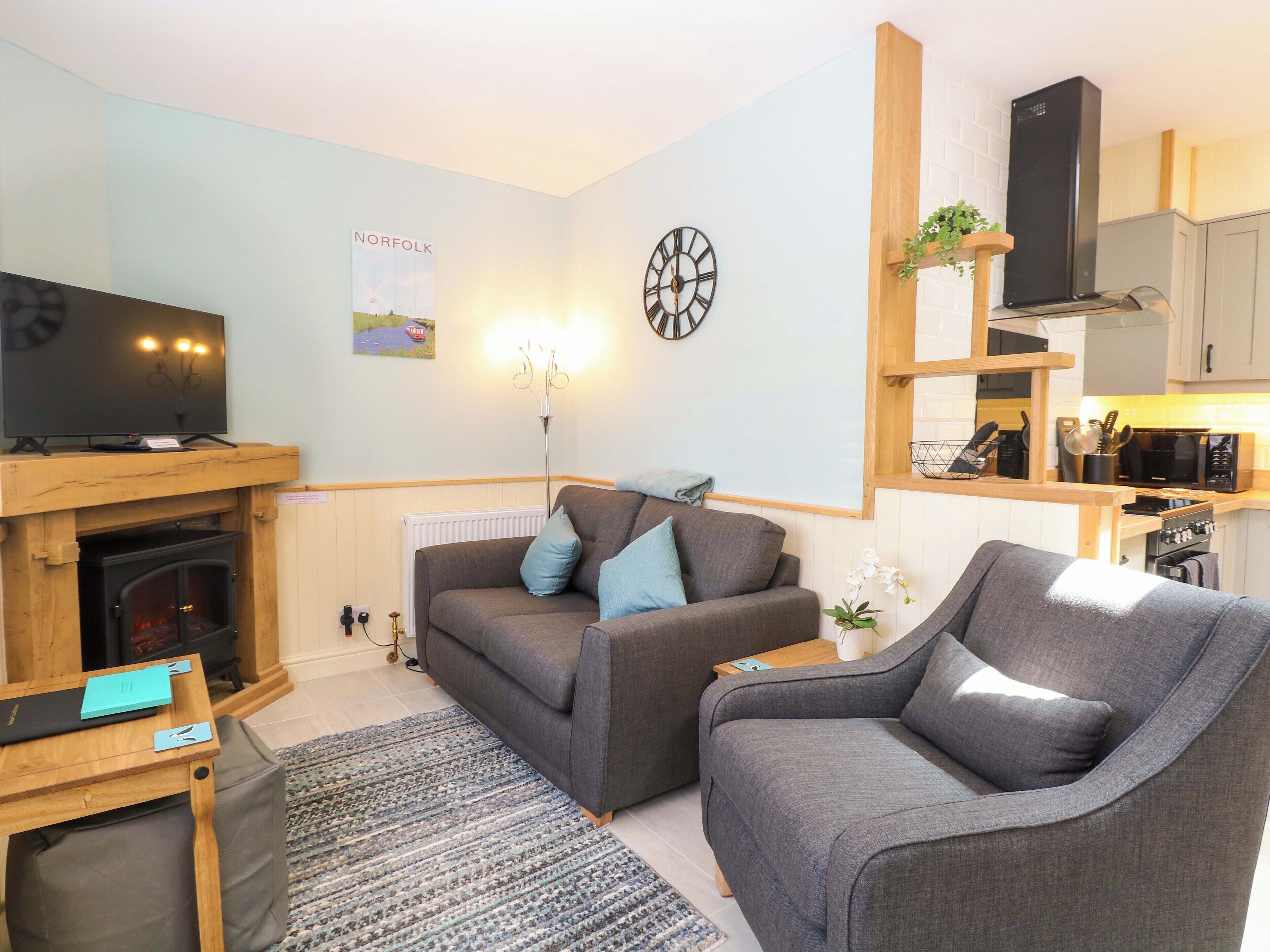 Una sala de estar acogedora con chimenea, televisión, sofá y un comedor con microondas.