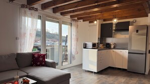 Una cocina moderna con armarios blancos y un refrigerador de acero inoxidable.